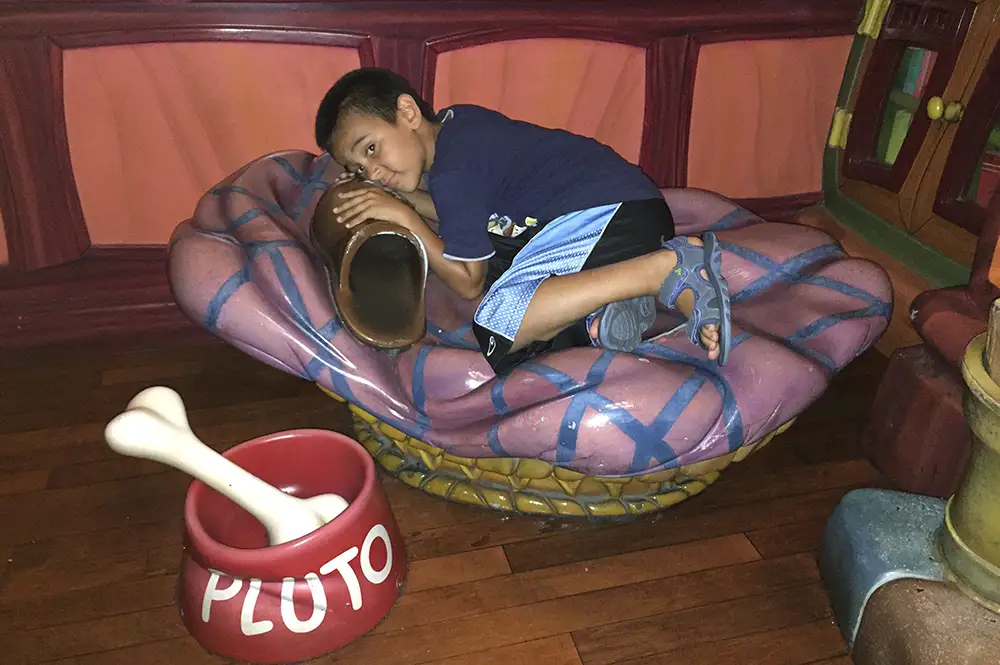 Grandkid sleeping in Pluto's dog bed.